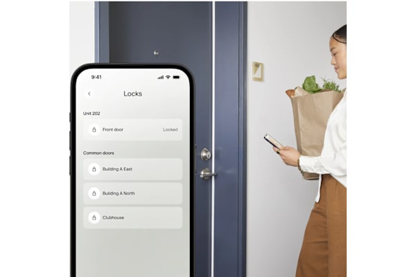 A woman is holding a smartphone and looking at a lock screen application.